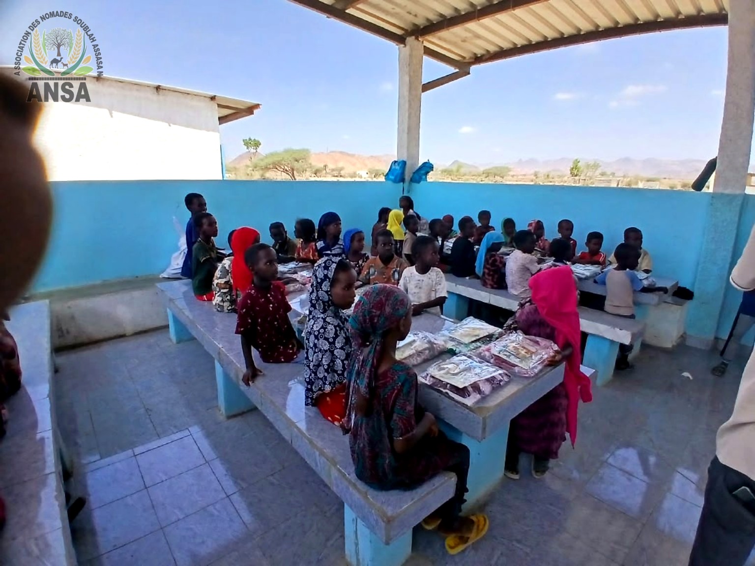 Élèves et familles autour des kits scolaires distribués à l’école d’Assasan
