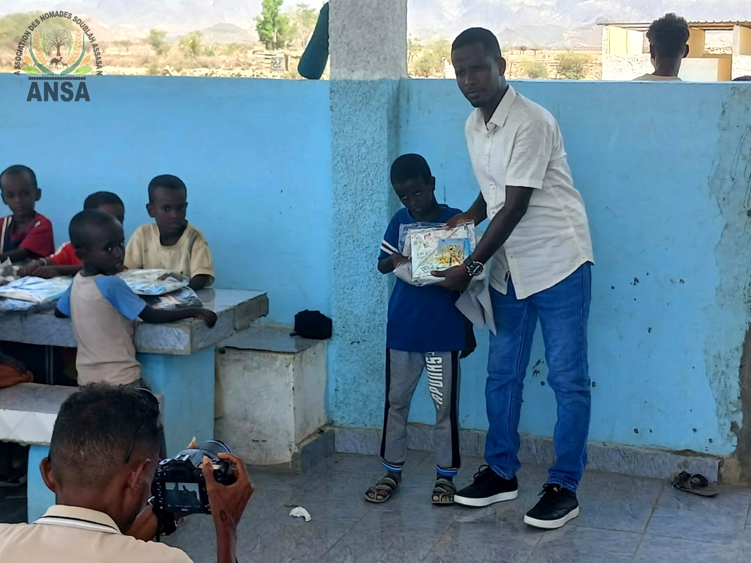 Remise d’un kit scolaire à un élève de l’école d’Assasan